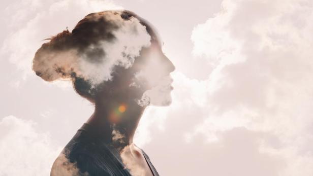 Transparente Frau schaut nach rechts in die Wolken