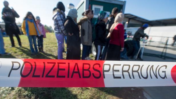 Eine Polizeisperre vor einer Gruppe von Menschen.