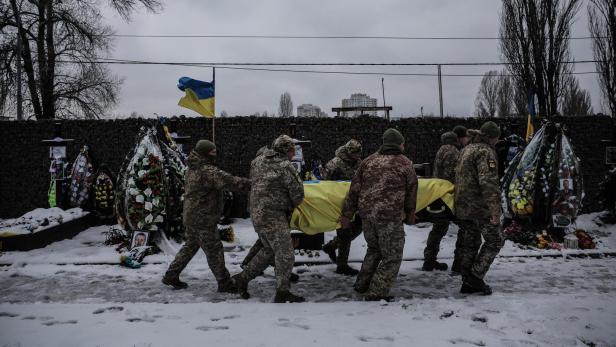 Ukrainische Soldaten tragen einen Sarg
