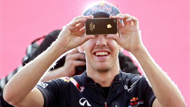 epa02952596 German Formula One driver Sebastian Vettel of Red Bull Racing uses a phone to take photographs of F1 fans before a autograph signing session at the Suzuka Circuit in Suzuka, western Japan, 06 October 2011. The Formula One Grand Prix of Japan will take place on 09 October 2011. EPA/DIEGO AZUBEL