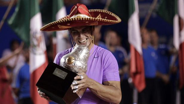 Rafael Nadal of Spain wearing a sombrero, a traditional Mexican hat, poses with his trophy after defeating compatriot David Ferrer during their men&#039;s singles final match at the Acapulco International tennis tournament in Acapulco March 2, 2013. REUTERS/Henry Romero (MEXICO - Tags: SPORT TENNIS)
