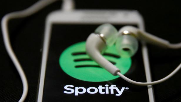 FILE PHOTO: Earphones are seen on top of a smart phone with a Spotify logo on it, in Zenica