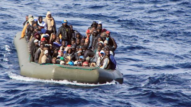 Ein überfülltes Schlauchboot treibt auf dem offenen Meer.