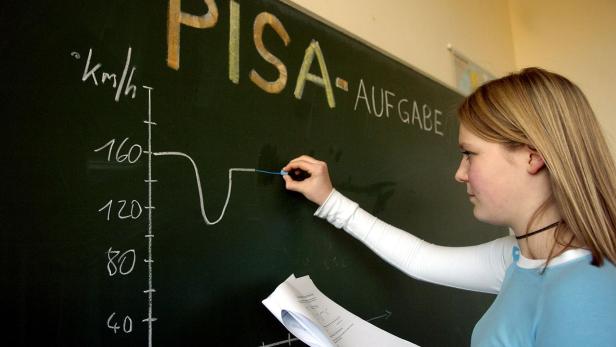 Pisa Symbolbild: Mädchen rechnet Aufgabe auf Tafel aus