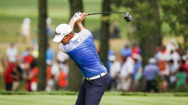 Ein Golfspieler schwingt seinen Schläger auf einem Golfplatz.