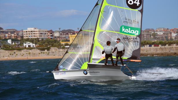 Zwei Segler steuern ein Segelboot mit der Nummer 84 auf dem Meer.