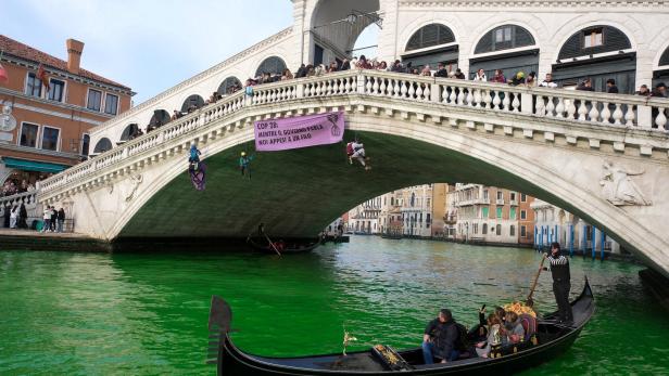 Aktivisten der Gruppe Extinction Rebellion seilten sich von der Rialto-Brücke ab und schütteten Farbstoff in das Wasser des Canal Grande