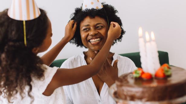 Eine Mama wird mit einer Geburtstagestorte überrascht.