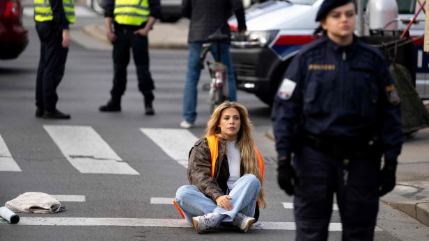 Symbolbild: Klimaaktivistin Anja Windl blockiert die Straße