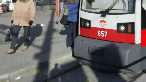 Eine Straßenbahn der Wiener Linien hält an einer Haltestelle.