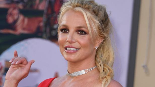 Britney Spears trägt ein rotes Kleid und eine Halskette.