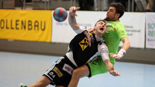Zwei Handballspieler kämpfen um den Ball.