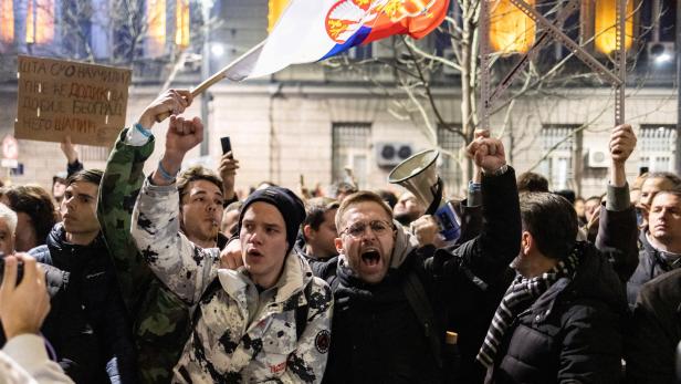 Zwei Demonstrierende, zwei junge Männer, in der Masse von Belgrad