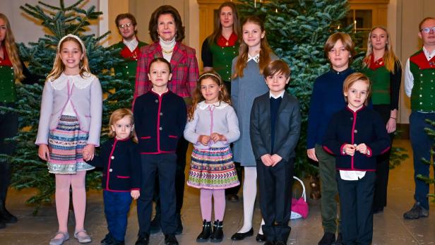 Die schwedische Königsfamilie posiert vor Weihnachtsbäumen.