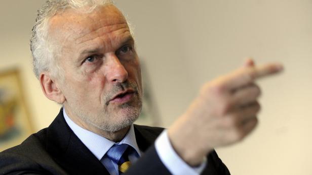 Ein Mann im Anzug gestikuliert mit dem Finger.