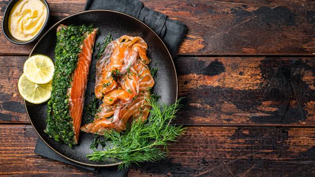 Gebeizter Lachs mit Dill und Zitronenscheiben auf einem Teller.