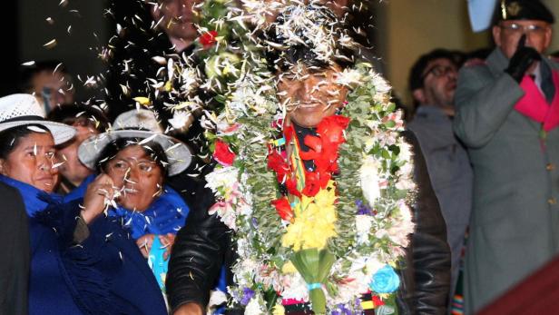 epa03774325 Bolivia&#039;s President Evo Morales (C), heavily garlanded as he is warmly welcomed on his arrival home at El Alto airport in La Paz, Bolivia, late 03 July 2013. He finally arrived home after an enforced stopover in Austria following France, Italy and Portugal&#039;s decision to refuse his plane permission to enter their airspace because of suspicion it carried fugitive U.S. spy agency contractor Edward Snowden. EPA/Martin Alipaz