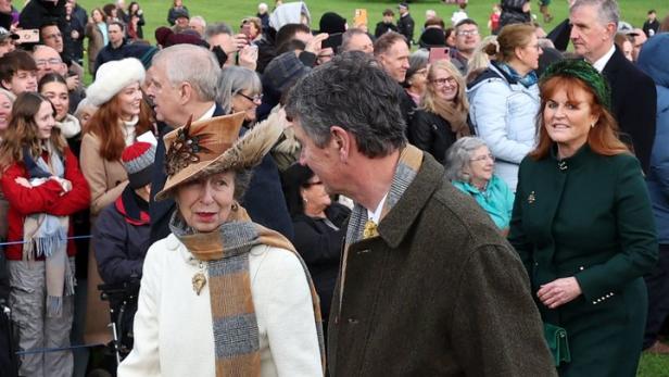 Prinzessin Anne geht mit einem Mann durch eine Menschenmenge.