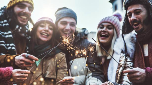 Eine Gruppe junger Leute feiert mit Wunderkerzen.