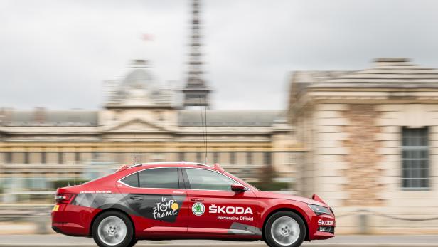 Ein roter Škoda, Partner der Tour de France, fährt vor dem Hintergrund des Eiffelturms.