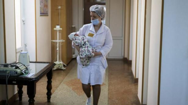 Russische Krankenschwester mit Baby im Arm.