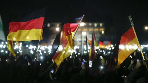 Leuchtende Handy-Displays und deutsche Flaggen beim Aufmarsch vom 8. Dezember