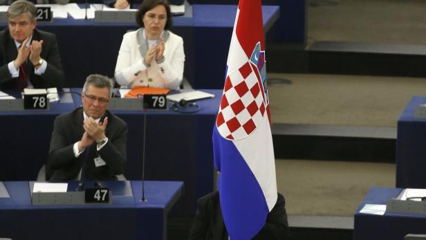 An husher of the European Parliament holds the flag of Croatia during a ceremony marking the start of Croatia&#039;s membership to the EU, at the European Parliament in Strasbourg, July 1, 2013. Two decades since fighting itself free of Yugoslavia, Croatia becomes the 28th member of the European Union on monday against a backdrop of economic woes in the Adriatic republic and the bloc it is joining. REUTERS/Vincent Kessler (FRANCE - Tags: POLITICS)