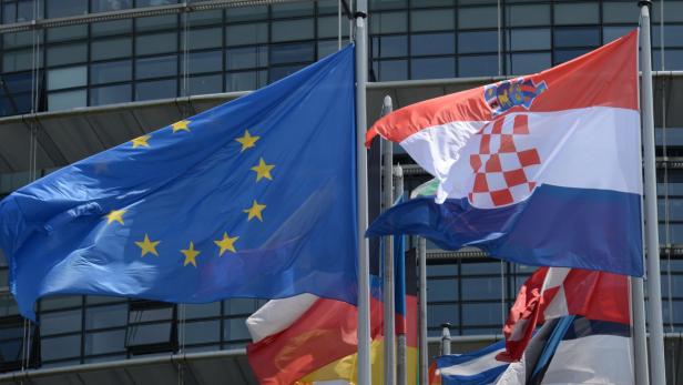 epa03771264 The Croatian flag (R) flies next to European flags outside the European Parliament in Strasbourg, France, 02 July 2013. Following the successful ratification of its European Union Accession Treaty by the national parliaments of the 27 Member States, the Republic of Croatia has joined the EU as the 28th member on 01 July 2013. EPA/PATRICK SEEGER