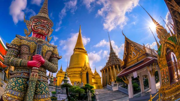 Eine Statue eines Wächterdämons vor dem goldenen Tempel Wat Phra Kaeo in Bangkok.
