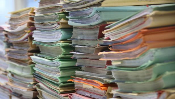 Mehrere Stapel von Aktenordnern und Papierdokumenten.