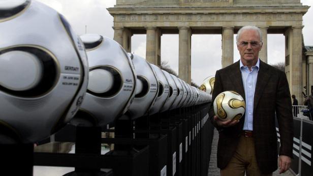 FILE PHOTO: President of Germany's World Cup organising committee Beckenbauer holds a soccer ball in Berlin