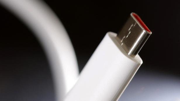 Ein weißes USB-C-Kabel vor einem dunklen Hintergrund.
