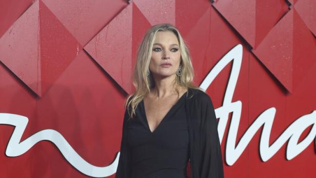 Kate Moss in einem schwarzen Kleid auf dem roten Teppich.