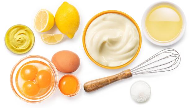 Die Zutaten für Mayonnaise sind auf einem weißen Hintergrund angerichtet.
