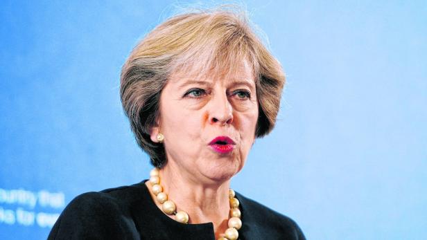 Theresa May spricht vor einem hellblauen Hintergrund.