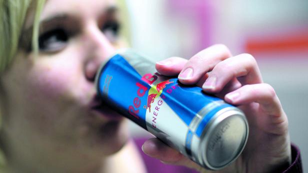 Eine Person trinkt aus einer Dose Red Bull Energy Drink.
