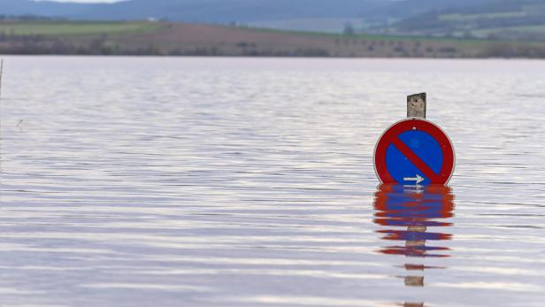 Hochwasser bedeckt ein Straßenschild