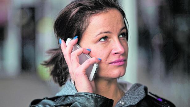 FILE PHOTO: A woman uses a mobile phone in north London