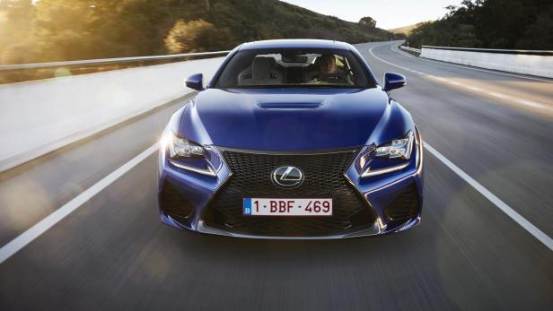 Ein blauer Lexus fährt auf einer Landstraße.