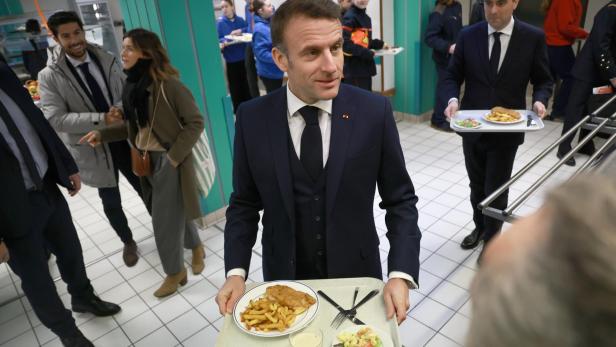 Der französische Präsident Macron in einer Kantine mit Tablett