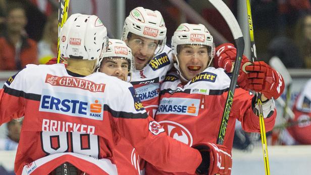 Eishockeyspieler in rot-weißen Trikots umarmen sich auf dem Eis.