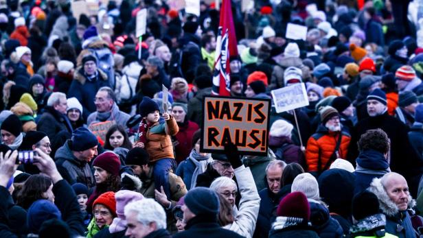 Demonstranten in Berlin halten ein Plakat hoch