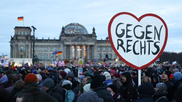 Viele Menschen und ein Schild mit der Aufschrift "gegen rechts" vor dem Berliner Bundestag