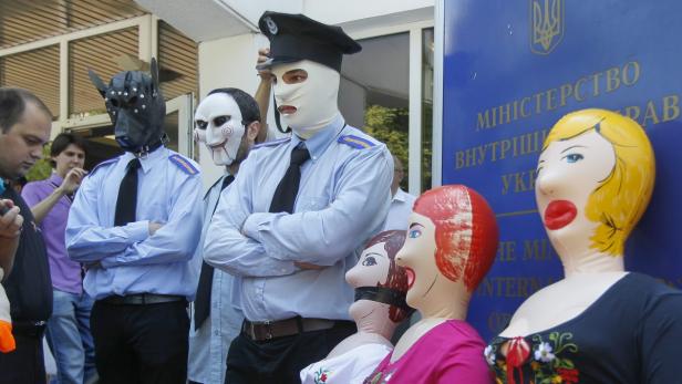 epa03774661 Activists of the Ukrainian Guy Fawkes movement, dressed in uniforms like policemen, protest with inflatable dolls under the slogan &#039;Better dolls than girls&#039; to support rape victim Iryna Krashkova in front of the Interior Ministry in Kiev, Ukraine, 04 July 2013. Ukrainian Iryna Krashkova, 29, was raped and battered near the village of Vradievka by two local police officers and a forest ranger on 27 June. EPA/SERGEY DOLZHENKO