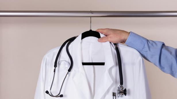 Medical white consultation coat with stethoscope being taken off