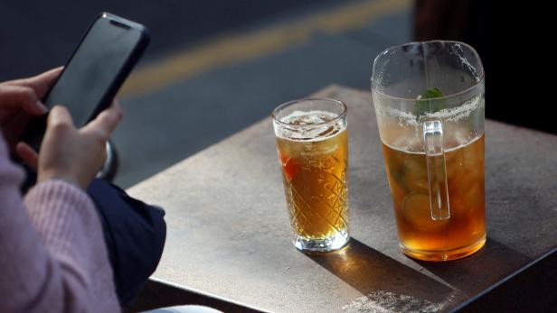 Eine Person sitzt im Wetherspoon und tippt ins Handy, vor ihr zwei Bier.