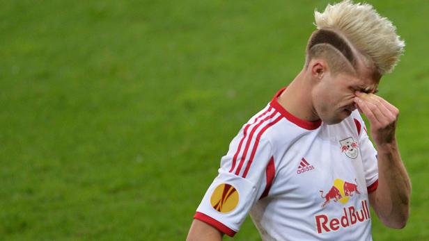 Ein Fußballspieler mit auffälliger Frisur reibt sich das Auge.