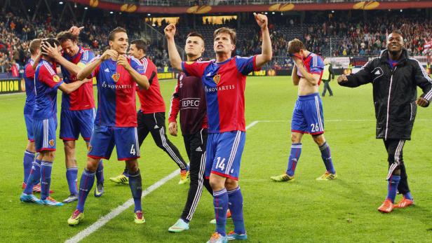 Fußballspieler des FC Basel feiern auf dem Rasen einen Sieg.