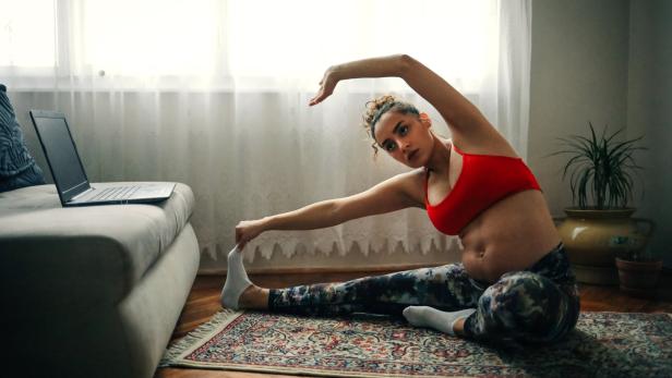 Frau Mutter macht yoga sport daheim