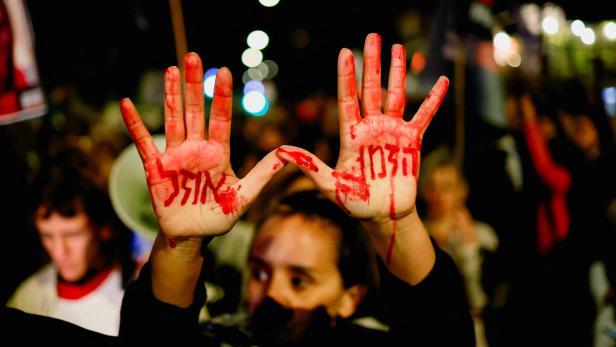 Proteste für eine baldige Freilassung der Geiseln in Jerusalem: Frau hält Hände in die Höhe mit der Aufschrift "Die Zeit läuft aus".